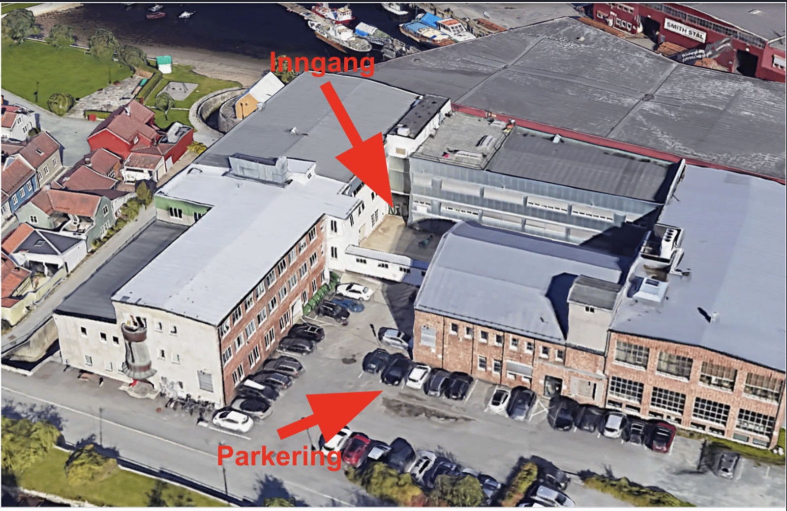 Flyfoto av Mellomila 56 med inngangen innerst i gårdsrommet og parkeringen foran bygget